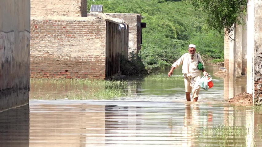 After flood man crossing a street filled with water. Royalty-Free Stock Footage #1094106841