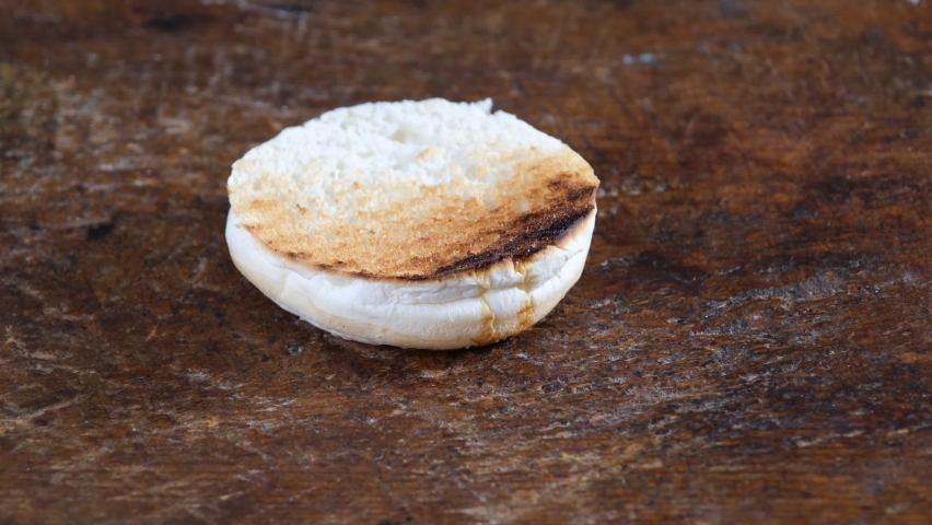 preparing gourmet burger, adding greens
