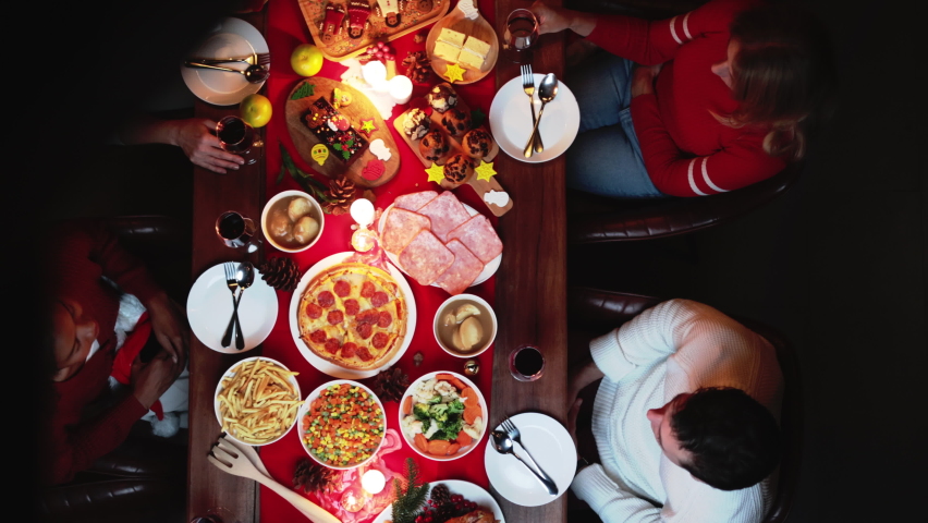 Groups of people celebrate Christmas eve and have dinner at night which have many food and wine on the table. | Shutterstock HD Video #1094110575