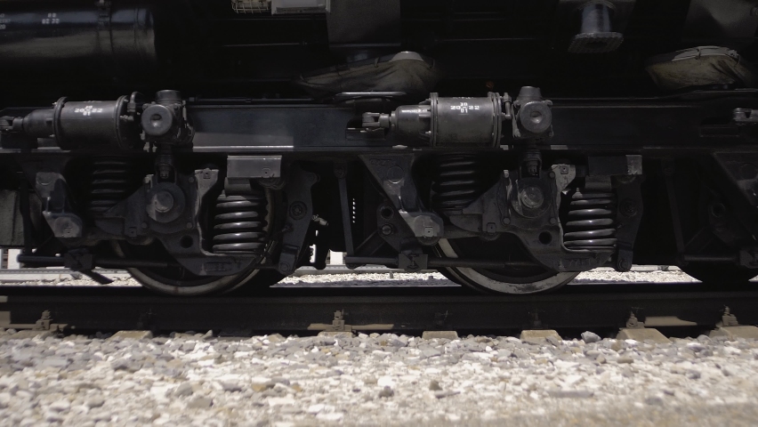 Wheelset locomotive pulling a train of tank cars with fuel on the railroad tracks. Close-up