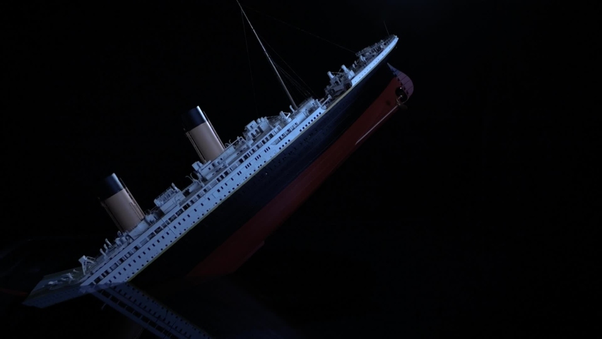 Steam transatlantic passenger liner splits and sinks after striking an iceberg. Half the boat has already sunk before the break-up. During its fall, the chimneys collapse. 1:200 Titanic Scale model Royalty-Free Stock Footage #1094133821