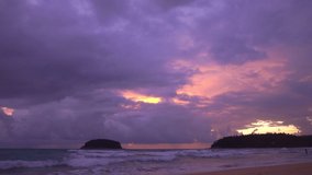 smooth waves hit on the beach at puple sunset.
purple clouds cover the ocean during colorful cloud in sunset at Kata beach Phuket.
video 4K. Scene of pink light in the sky background.

