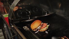 Barbecue grilled hamburgers. Male hands in gloves, the chef in the kitchen of the restaurant. Cooking fresh hamburger. Man making delicious sandwich. Preparation of tasty but unhealthy fast food