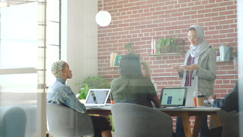 Muslim woman, meeting leader or global digital marketing teamwork and laptop in creative office boardroom. Happy smile or inclusive business people in social media brand planning or workshop training | Shutterstock HD Video #1094146429