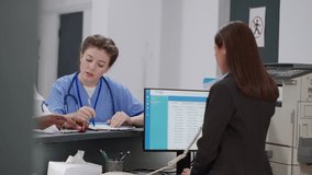 Diverse medical team working at hospital reception desk ith receptionist, analyzing checkup papers to help with healthcare appointments. Specialists writing insurance report at registration counter. - Powered by Shutterstock - Get 15% off with code: PIKWIZARD15