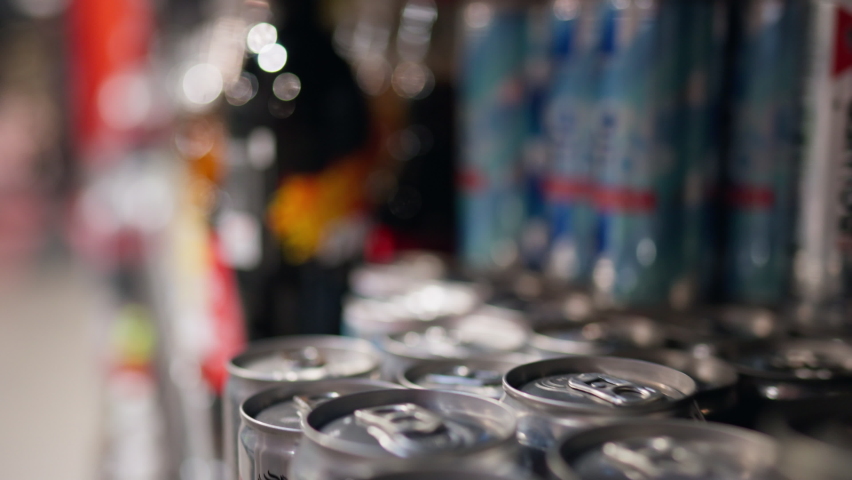 The female hand of a white girl takes a metal can with beer reads the composition, studying the composition of the drink in a tin metal can. Buying soda in a supermarket store, Studying information
 Royalty-Free Stock Footage #1094149745
