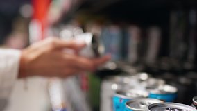 The female hand of a white girl takes a metal can with beer reads the composition, studying the composition of the drink in a tin metal can. Buying soda in a supermarket store, Studying information
 - Powered by Shutterstock - Get 15% off with code: PIKWIZARD15