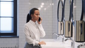 African-American schoolgirl talk on smartphone standing in campus toilet. Portrait of teen student having phone call in school bathroom - Powered by Shutterstock - Get 15% off with code: PIKWIZARD15