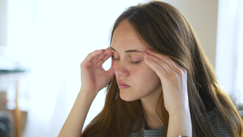 Sad girl suffers from headache. Man suffering from migraine. Emotional fatigue disorder close-up of girl face. Pain in child face. The concept of migraine and headache. Anxiety about a health problem | Shutterstock HD Video #1094180259