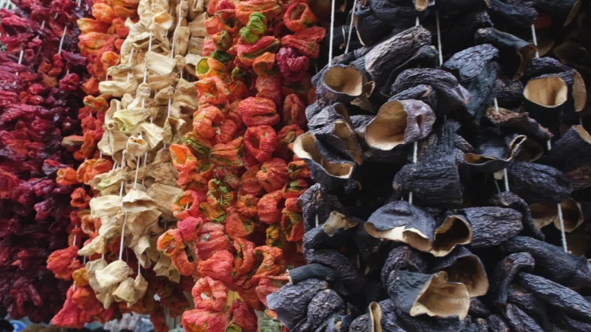 Dry eggplant, tomato and pepper hang on the threads of the market. Dehydrated local vegetables as an ingredient for oriental cuisine. Royalty-Free Stock Footage #1094184383