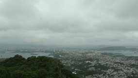 Udaipur, Rajasthan, India - September 10, 2022 : Clouds on Udaipur city time-laps video, view of Sajjangarh Palace with black birds, Udaipur Arial time-laps