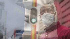 Animation of flag of france waving over african american man wearing face mask in city street. global health precautions during covid 19 pandemic concept digitally generated video.