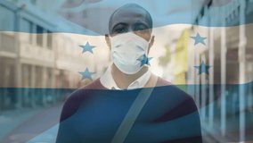 Animation of flag of honduras waving over african american man wearing face mask in city street. global health precautions during covid 19 pandemic concept digitally generated video.