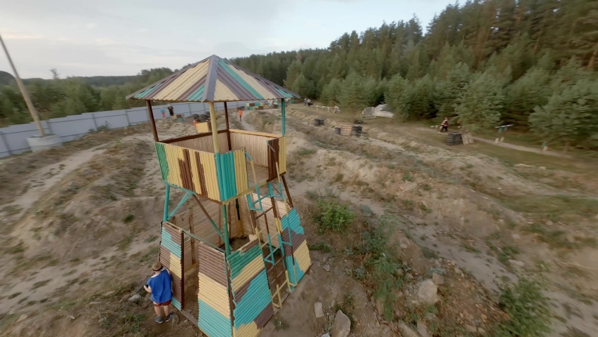 FPV drone view of Kids having fun playing laser tag outdoor
