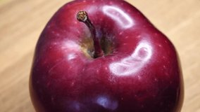 Single apple close-up. An apple of the red chief variety. Highlights on the apple peel. Highly detailed video. Delicious fruit.