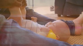 Animation of light trails over caucasian father and his son playing together. Lifestyle and family concept digitally generated video.