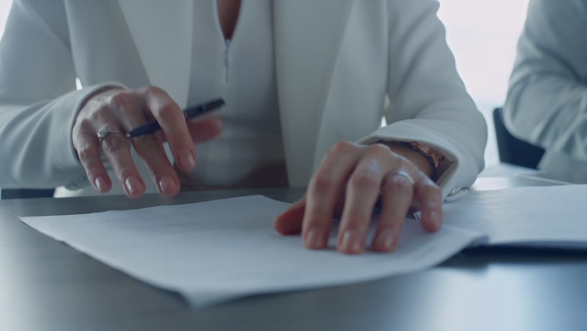 Closeup hand holding pen writing papers in suit. Divorcing woman signing documents in attorney office. Unrecognized client taking bank loan checking agreement. Freelancer ceo concluding financial deal