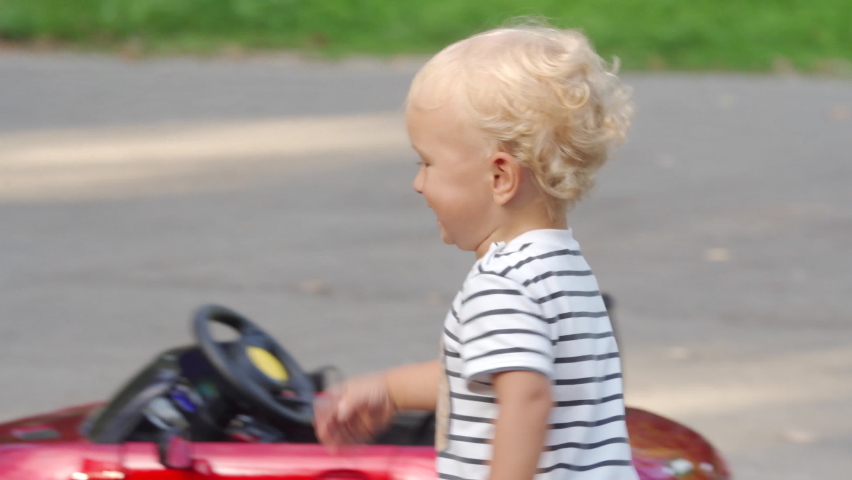 Happy kid running in the park in summer 1.5 year old toddler playing with mother outdoors. Laughing little child having fun playing outside.
