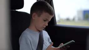 The boy passenger listens to his favorite songs through headphones or watches popular viral videos on social networks.