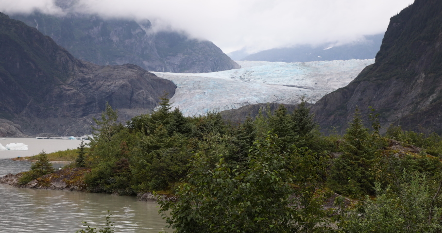 Mendenhall Glacier forest Juneau Alaska. Cruise ship destination near Juneau Alaska. Climate change global warming result is rapidly retreating, shrinking, and melting. Large lake formed. Royalty-Free Stock Footage #1094205893