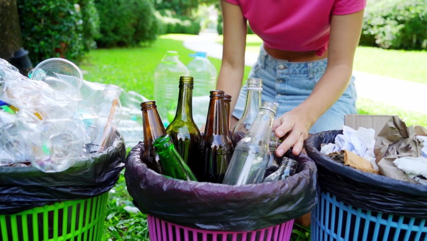 Young woman sorting glass trash in the yard of the house Royalty-Free Stock Footage #1094209607