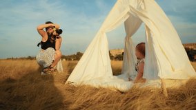 photographer shoots happy birthday of baby and family, lifestyle and autumn sunset with tent in field.