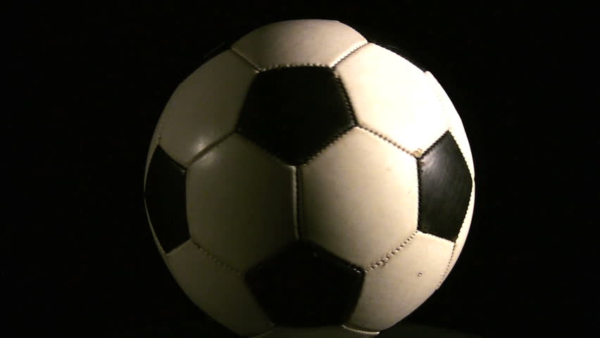 A Soccer ball spinning over a black background