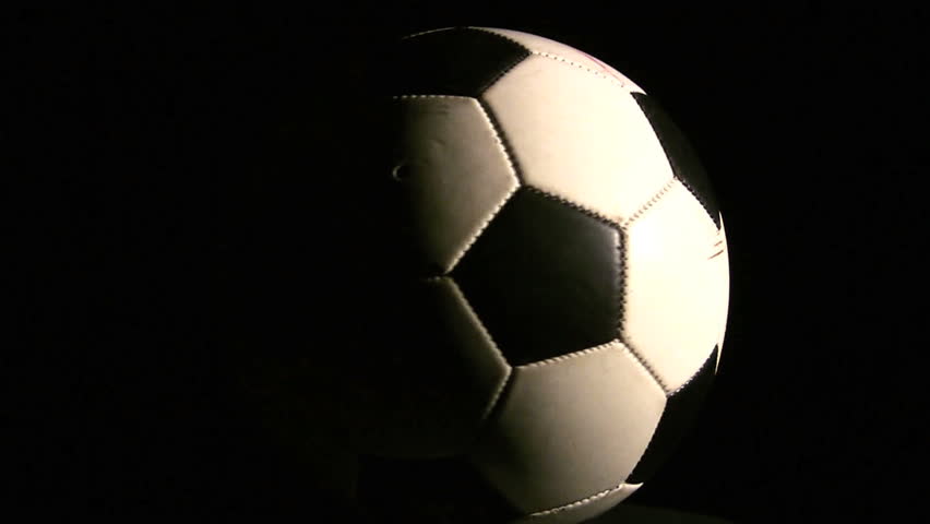 A Soccer ball spinning over a black background
