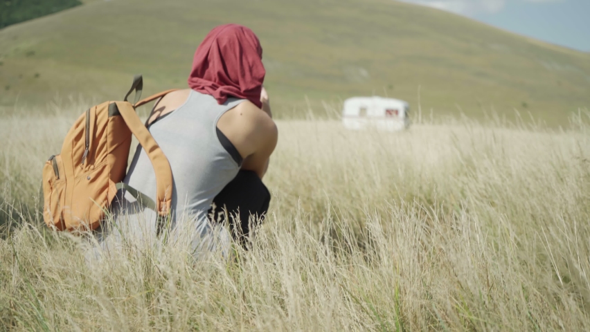 Young Girl Taking A Picture Of An Isolated Camper In The Distance