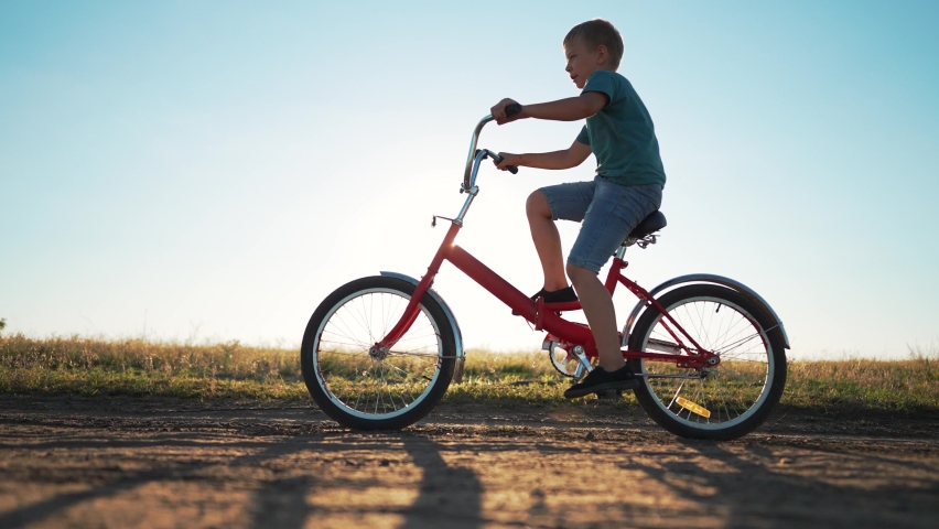 Kid is learning to ride bike. child of family rides bicycle on rural road.happy Kid are everywhere on street.Travel by bike in summer. cheerful kid rides bike in summer park.go everywhere.Happy family Royalty-Free Stock Footage #1094244861