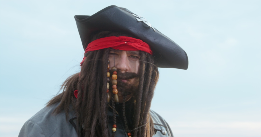 Cosplay, image of cute pirate in hat with dreadlocks, mustache, beard. Man in carnival costume of sea corsair, robber, halloween. Performance of animator at children's holiday. Pirate quest Royalty-Free Stock Footage #1094247585