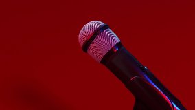 Microphone on stage close-up. Mic rotating. Karaoke, night club, bar. Music concert. Song, music concept. 4K UHD slow motion video. Seamless looping. 3d animation.
