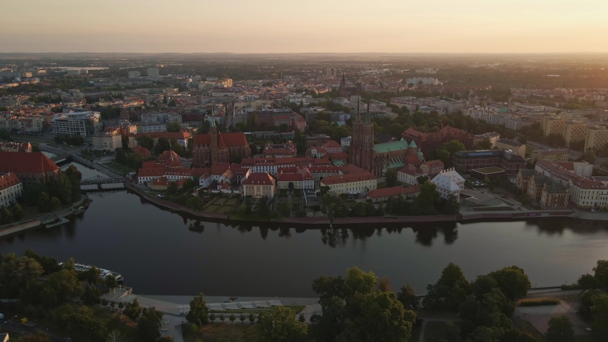 Drone flight over Tumski island and Cathedral of St John the Baptist in Wroclaw at morning sunrise light, Aerial view of old town with historical architecture in Wroclaw city, Poland