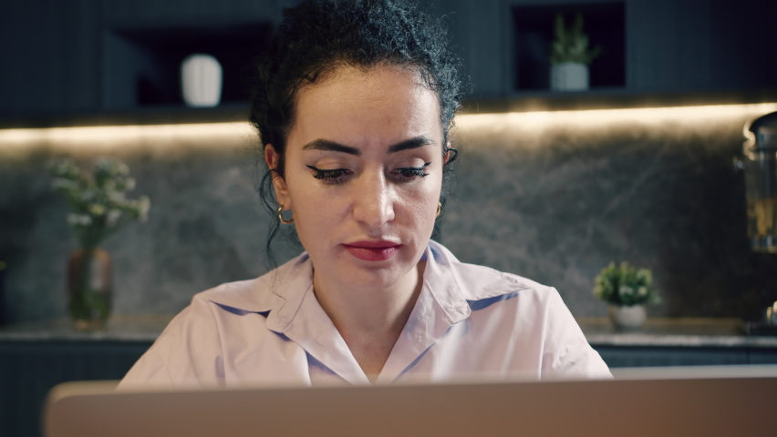 Caucasian serious woman freelancer working on a laptop sitting in office or home kitchen, using laptop, working on the laptop. Concept online work at home. Royalty-Free Stock Footage #1094255021
