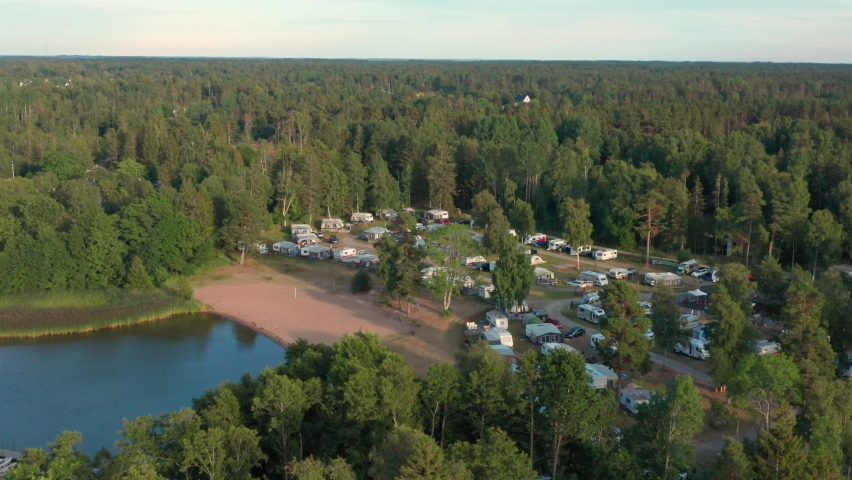 Sunset evening night on camping ground at lake. Camp sight quite at night in aerial drone shot. ´Trailer or caravan park temporary area for mobile homes and travel trailers, Sweden Royalty-Free Stock Footage #1094255971
