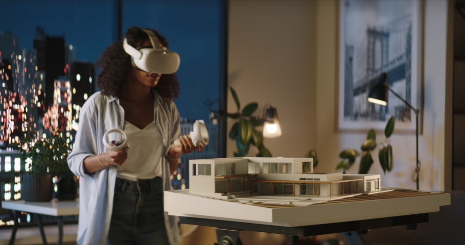 Portrait of African American female architect or student using a virtual reality VR headset to work on a house project late at night, preparing for presentation with a client Royalty-Free Stock Footage #1094256201