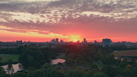 Upwards shot revealing the sunrise and skyline in The Hague, Netherlands, filmed at the zuiderpark (southern park) of the city Adlı Stok Video