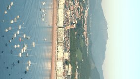 Vertical High angle view of San Sebastian city. View of La Concha Bay and beach with yachts docked in the middle of the bay area. Static video at sunset. Good Shepherd Cathedral in background
