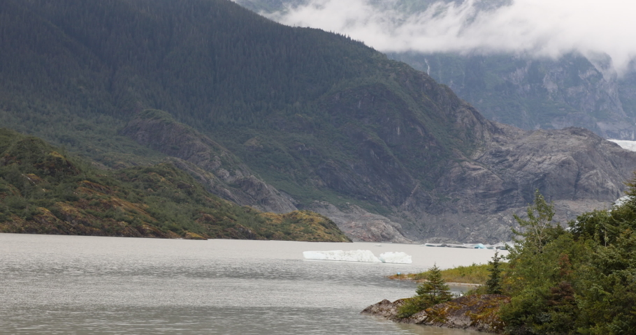 Mendenhall Glacier Nugget Falls Juneau Alaska pan. Cruise ship destination near Juneau Alaska. Climate change global warming result is rapidly retreating, shrinking, and melting. Large lake formed. Royalty-Free Stock Footage #1094260243