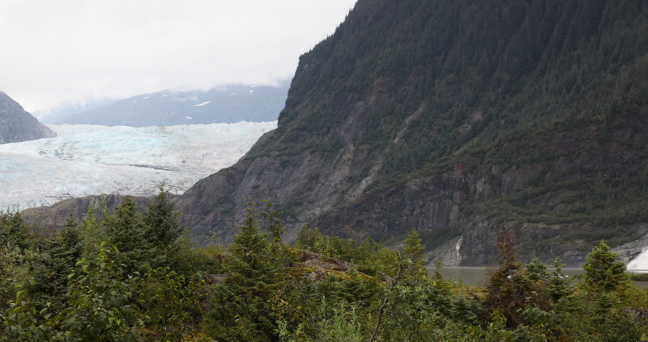 Mendenhall Glacier Nugget Falls Juneau Alaska pan. Cruise ship destination near Juneau Alaska. Climate change global warming result is rapidly retreating, shrinking, and melting. Large lake formed. Royalty-Free Stock Footage #1094260243