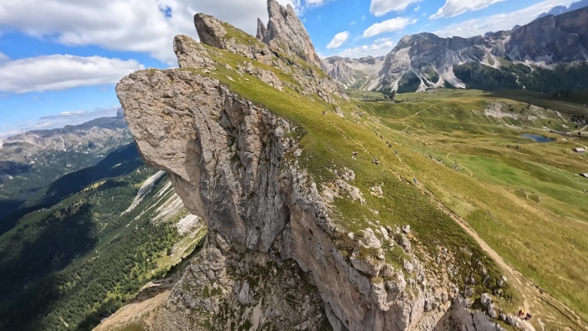 The Dolomites mountain range Italy part of the Southern Limestone Alps. First person view mountain aerial Hiking trekking majestic rugged cliffs with green grass. Unesco world heritage landscape.