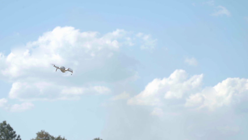 A drone flying outdoor hovering mid air, spinning around in open country side. Wide shot