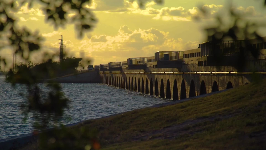 Florida Keys Causeway Bridge, old US1, during sunset, orange dramatic skies, blue ocean, green mangroves