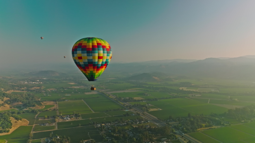 Aerial view of hot air balloon rising over small town in the Napa Valley Royalty-Free Stock Footage #1094269055