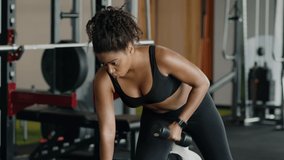 Body building concept. Young active motivated african american woman athlete pumping dumbbell at gym, working out on chest muscles, slow motion - Powered by Shutterstock - Get 15% off with code: PIKWIZARD15