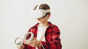 Boy using virtual reality glasses with controllers, playing video games, child gamer wearing new generation gaming headset for entertainment and education, future technology concept.