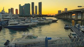 Aerial video of yachts at a miami florida marina during sunset, smooth, luxury with view of miami skyline