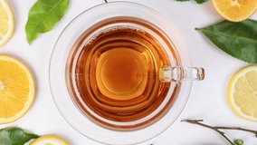 different types of fresh raw green tea leaf flower bud lemon orange slice transparent glass teacup saucer liquid tea on white background top view pan zoom rotate  - Powered by Shutterstock - Get 15% off with code: PIKWIZARD15