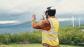 Medium shot of professional engineer wearing AR headset to virtualize operate wind turbine. New trend virtual augmented reality technology for sustainable energy. Virtual Industrial work space. - Powered by Shutterstock - Get 15% off with code: PIKWIZARD15