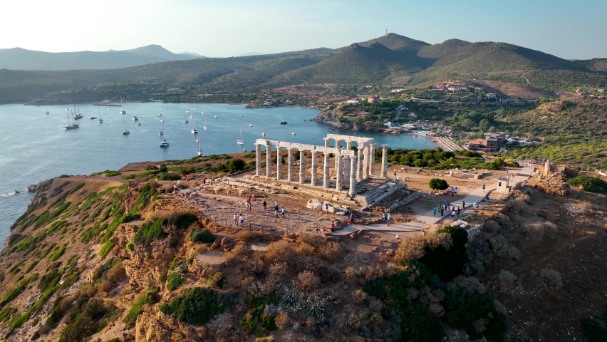 Aerial view of the beach and Temple of Poseidon at Cape Sounion at the edge of Attica, Greece, during summer sunset time Royalty-Free Stock Footage #1094287563
